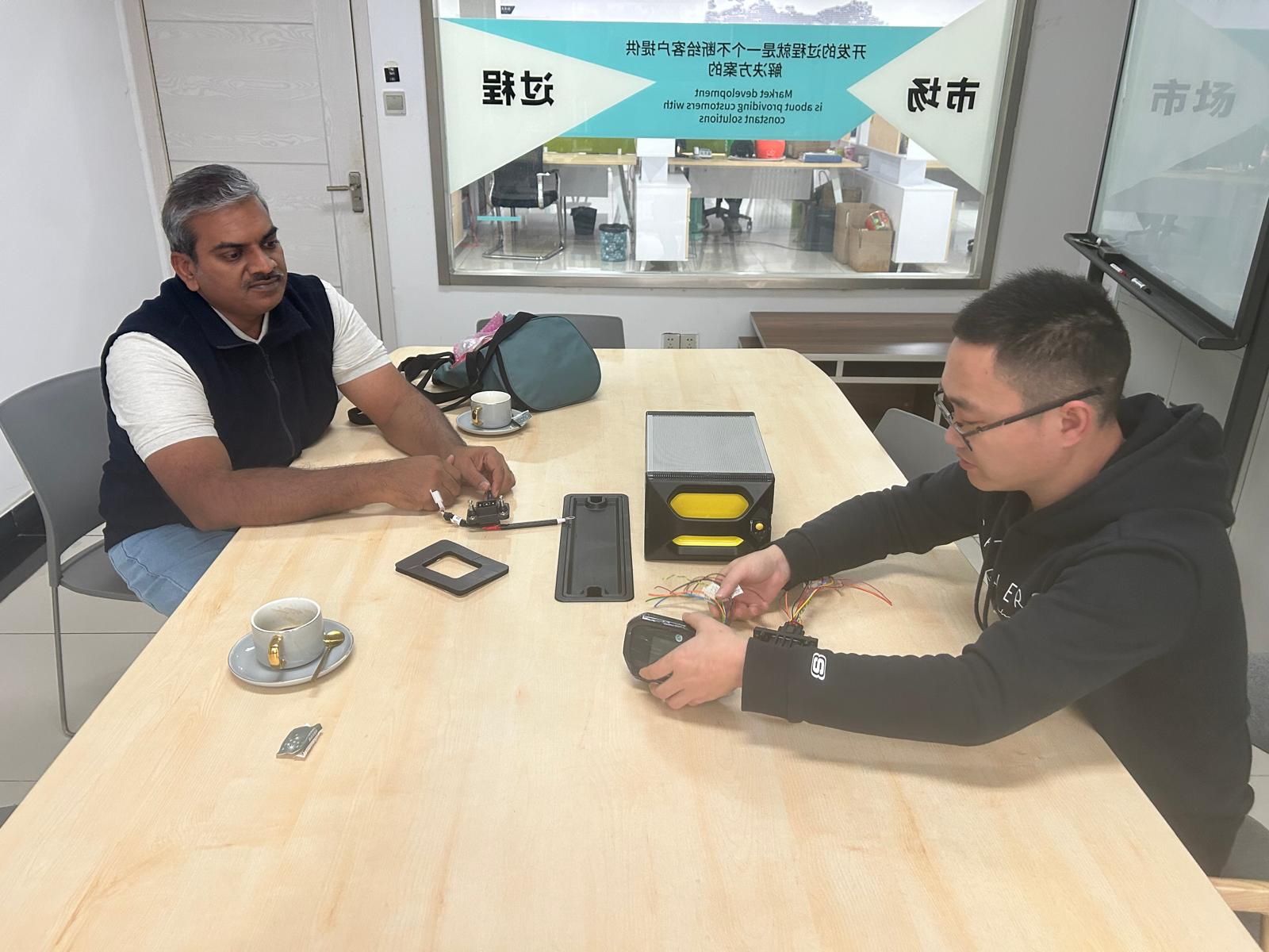 Two men sat talking at a desk