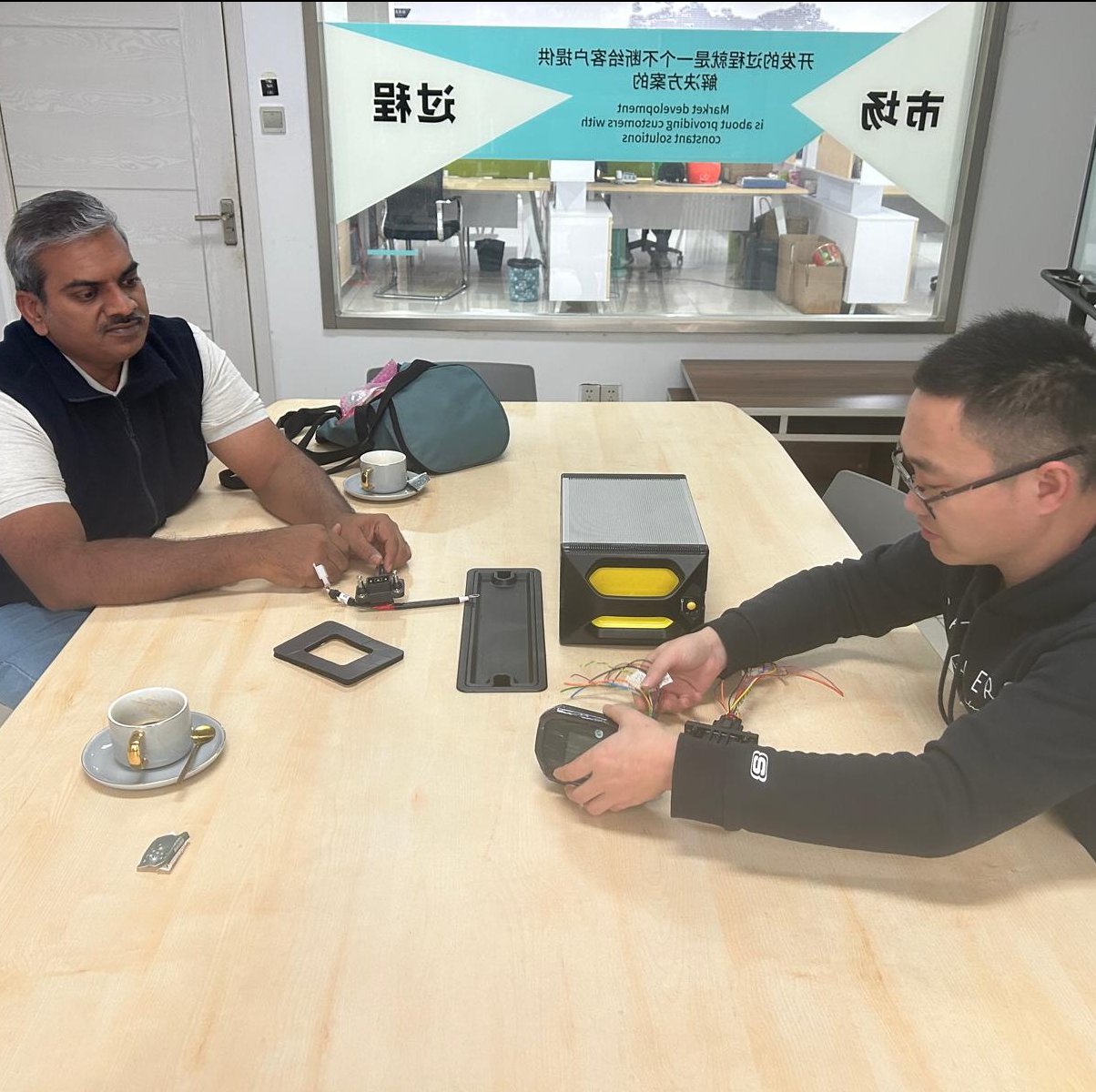 two men sat talking at a desk