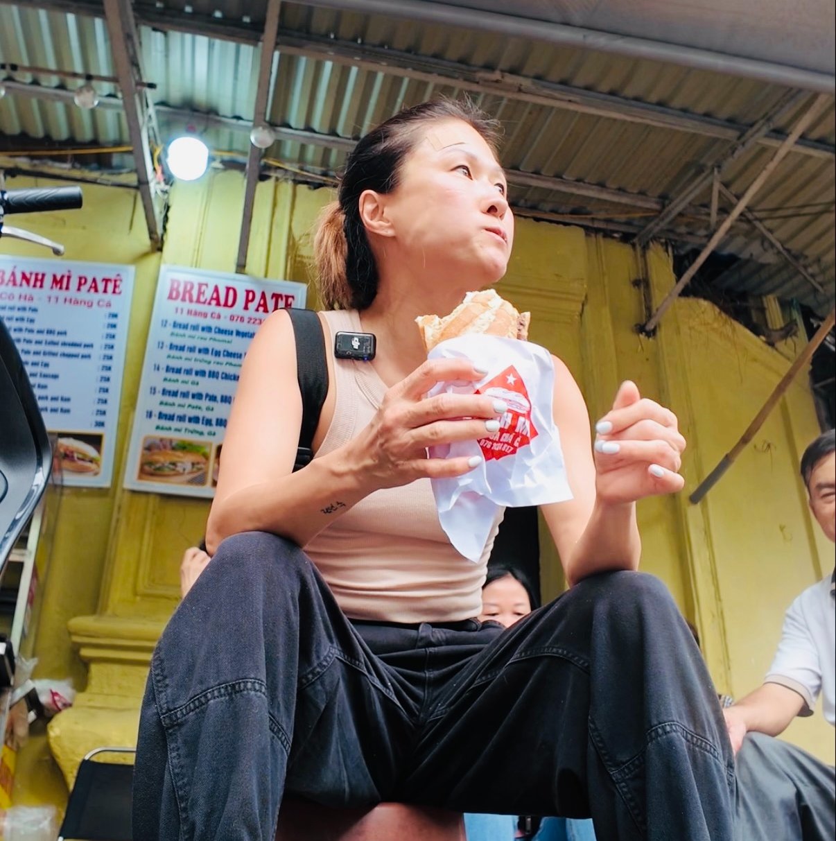 Young lady eating street food in Hanoi