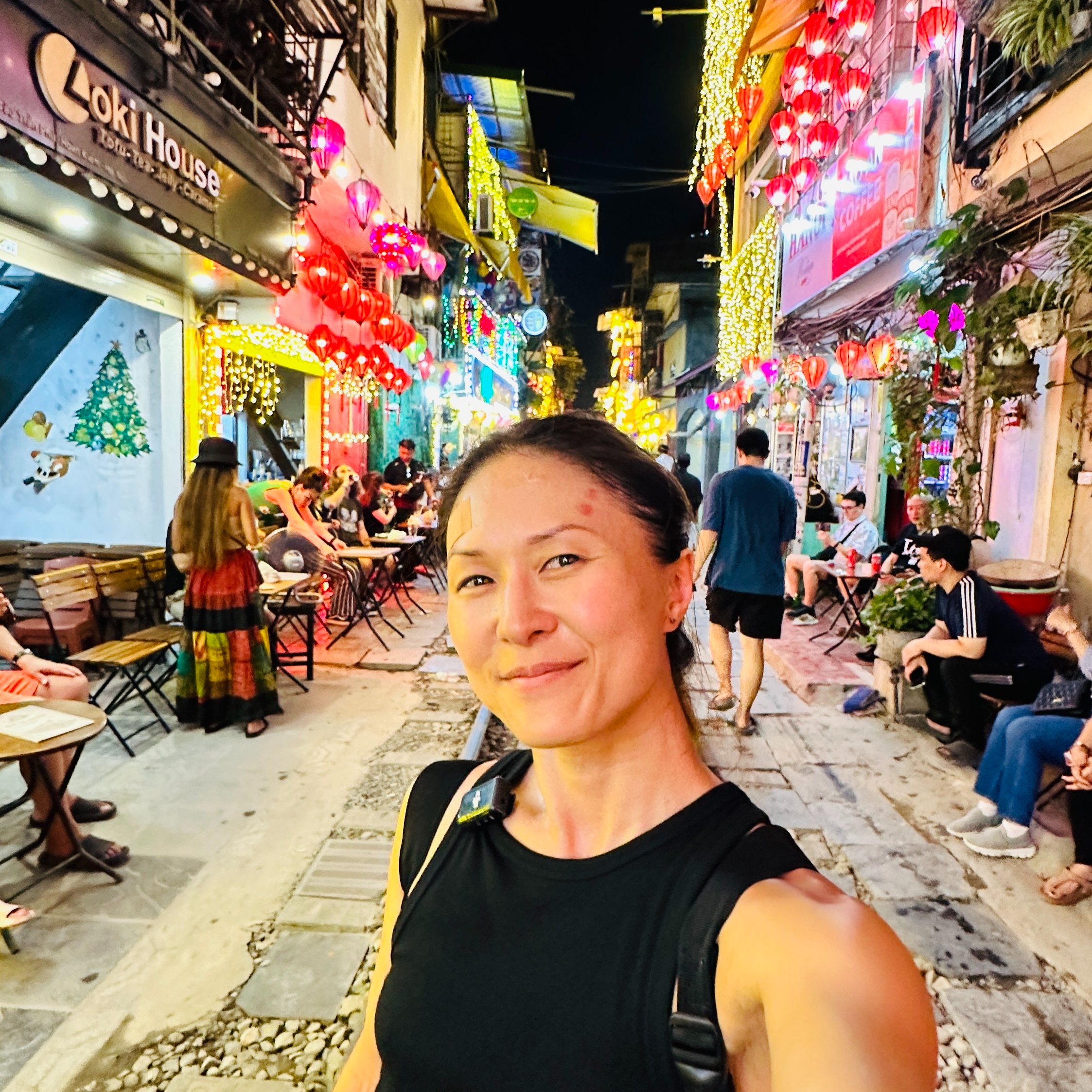 Lady taking selfie on Train Street in Hanoi surrounded by Neon