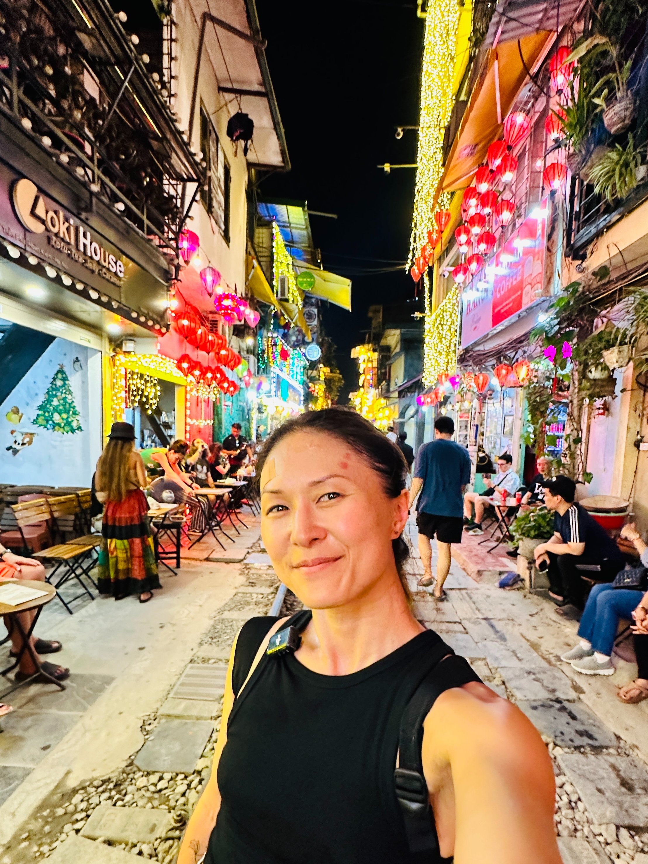 Lady taking selfie on Train Street in Hanoi surrounded by Neon