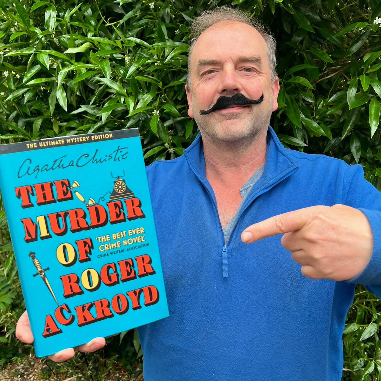 Gardening expert Simon Akeroyd sports a Hercule Poirot moustache and a copy of The Murder of Roger Ackroyd by Agatha Christie.
