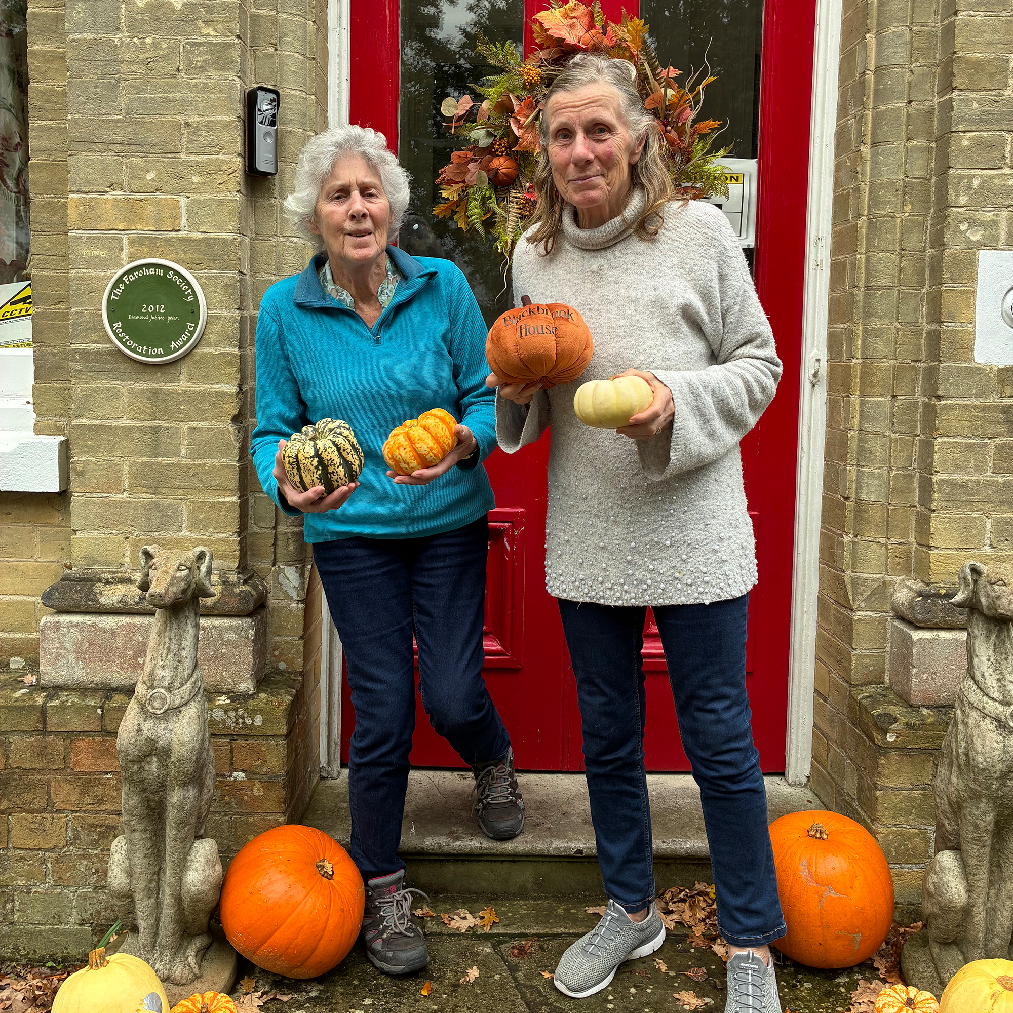 Residents of Blackbrook House Residential Care Home outside the front door, holding pumpkins