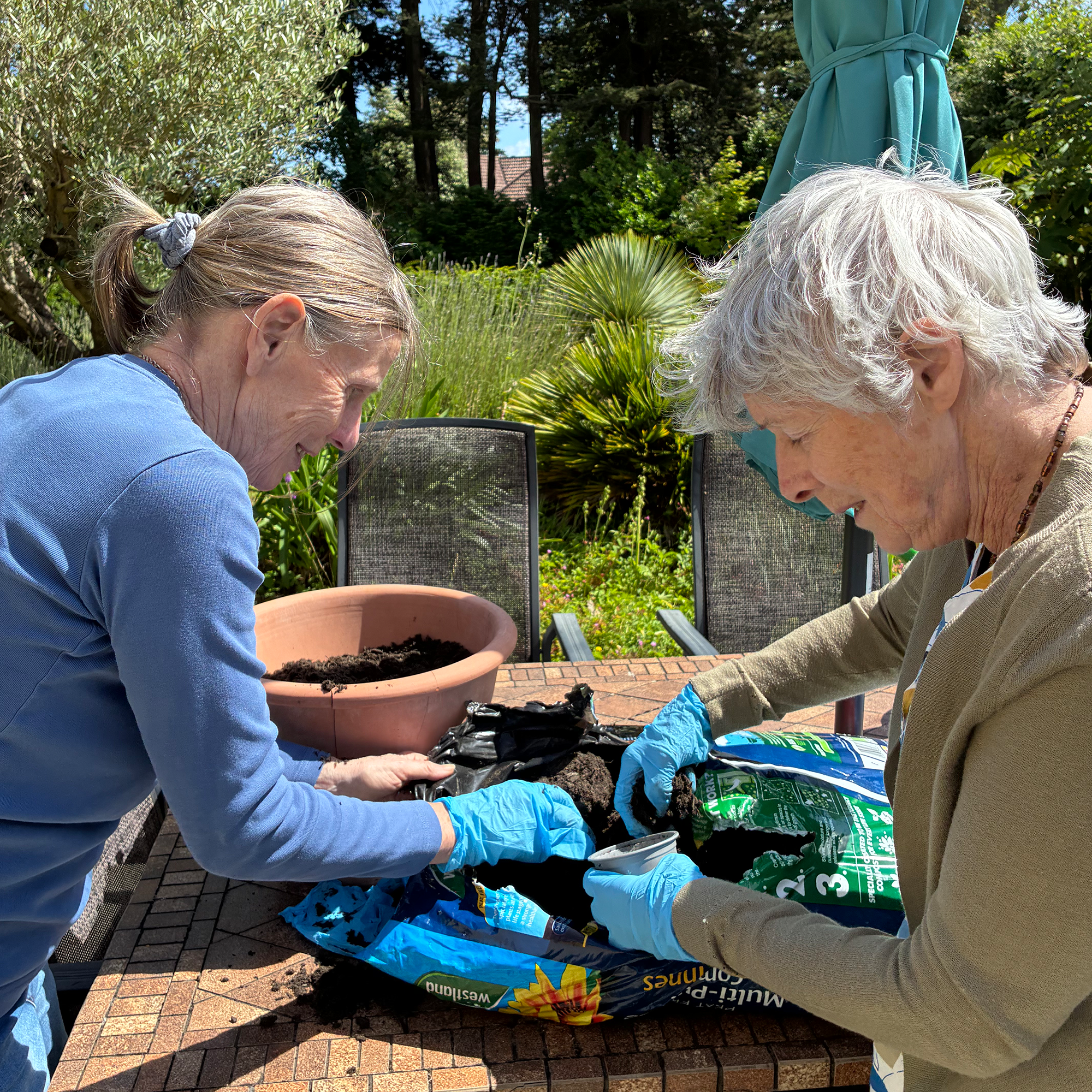 Two residents at Blackbrook House Residential Care Home planting up vegetables.