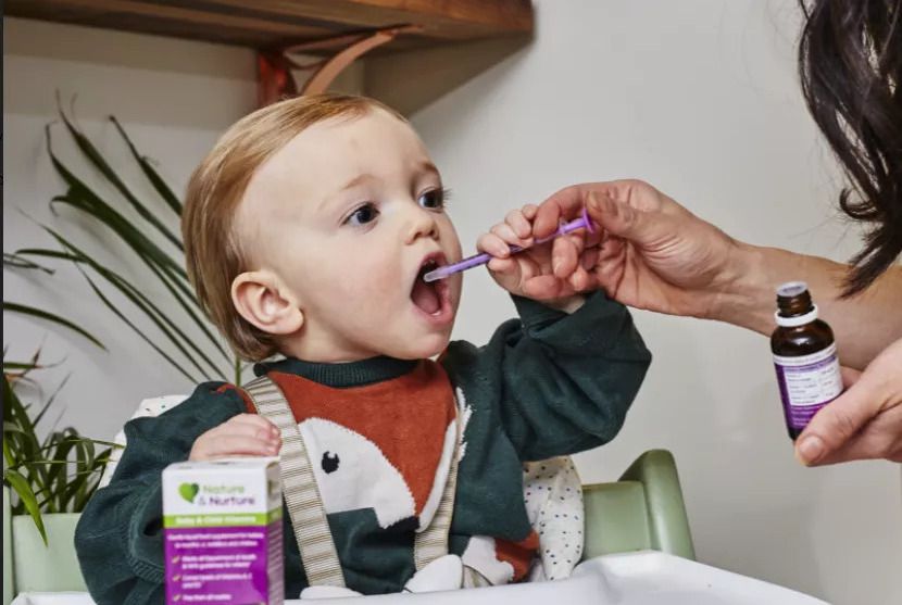 Mother spoon feeding baby